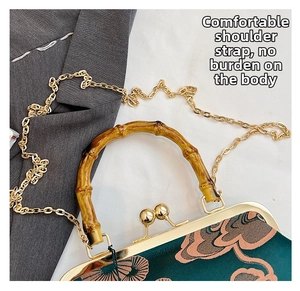 Detail der Vintage Qipao-Tasche mit Bambusgriff und goldener Kettenriemen