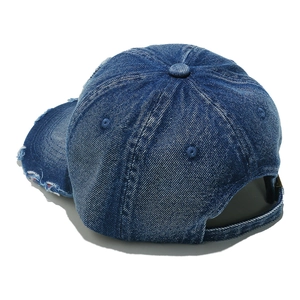 Detail of adjustable metal buckle and distressed denim texture on navy baseball cap