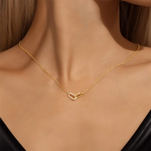 Close-up of interlocking double loop pendant with cubic zirconia on a gold clavicle chain
