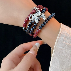 Detail of bohemian multilayer beaded bracelet with silver elephant charm on wrist