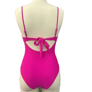 Detail view of the rose pink one-piece swimsuit featuring an elegant back bow tie design