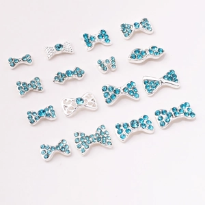 Close-up of blue rhinestone bow nail art charms with silver metal alloy base