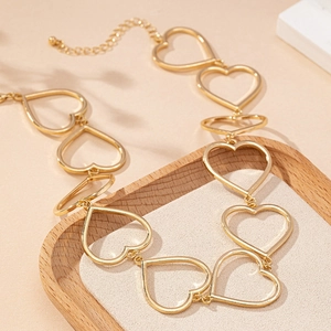 Elegant gold hollow heart necklace with adjustable link chain on a wooden display tray
