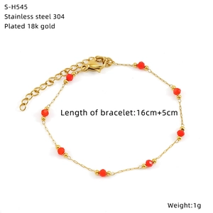 Detail of 18k gold plated stainless steel chain bracelet with faceted red glass beads