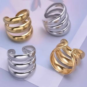 Close-up of gold and silver multi-layer stainless steel rings on a purple background
