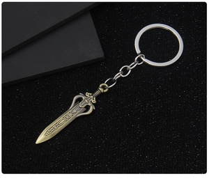Detailed macro view of vintage bronze sword keychain with intricate embossed patterns