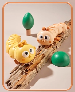 Detail of colorful clockwork caterpillar toys crawling on natural weathered wood decor