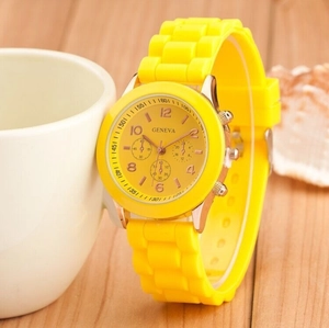 Close-up of yellow Geneva silicone watch leaning against a ceramic cup on a wooden table