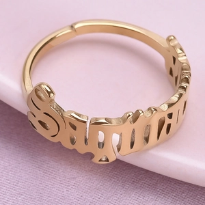 Detailed macro view of the gold Sagittarius zodiac cut-out lettering on an open ring