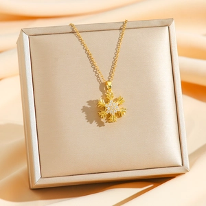 Elegant rotating snowflake necklace in gold finish with sparkling pavé zircons