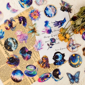 Flat lay of vintage celestial PET stickers with nebula patterns on old newspaper