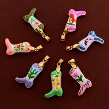 Detailed view of boot-shaped enamel pendants with colorful painted fruit and floral patterns