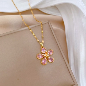 Elegant gold chain necklace with a pink five-petal flower pendant and crystal accents