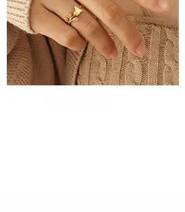 Close-up of a gold tulip-shaped open ring styled with a brown knit sweater