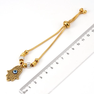 Détail du bracelet Hamsa doré avec breloque Mauvais Œil et fermoir coulissant réglable