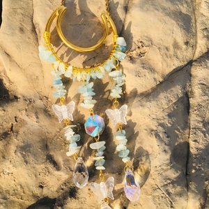 Detail showing blue crystal stones and butterfly pendants on a gold suncatcher