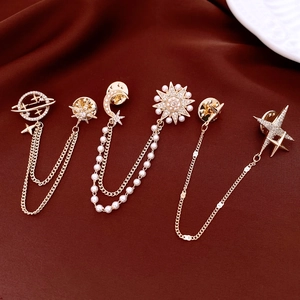 Macro shot of 14K gold plated celestial brooch with sparkling zircons and pearl accents