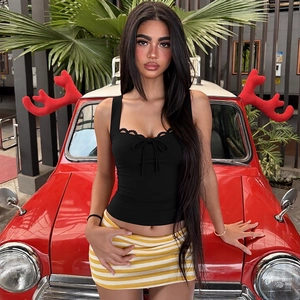 Dettaglio canotta in pizzo nero con fiocco e minigonna in maglia a righe gialle e bianche