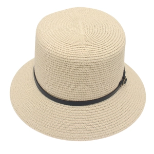 Dettaglio ravvicinato di cappello di paglia beige con cinturino in pelle nera e fibbia