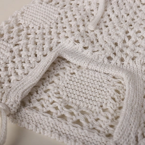 Gros plan du bonnet au crochet beige montrant la maille ajourée et les détails du cordon