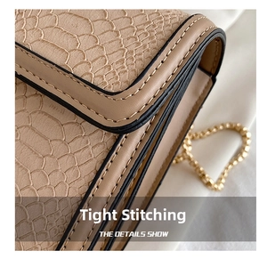 Close-up of precise double stitching and snake-pattern embossed leather on the beige bag