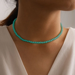 Close-up of elegant single-layer green pearl choker necklace on a female model