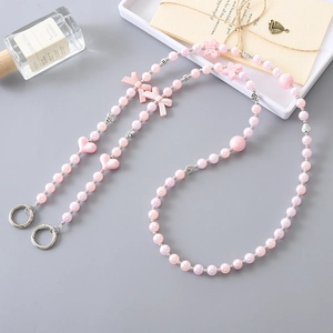 Handmade pink beaded strap with pearls and bow accents for phone cases or bags