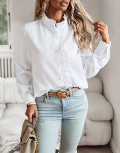 Détail de chemise blanche texturée à manches longues avec patte à volants et col montant