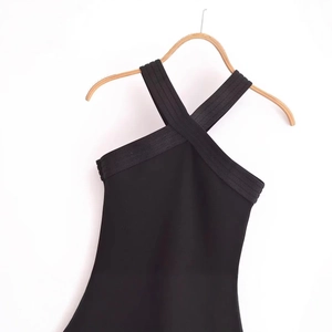 Robe noire élégante dos nu sans manches présentée sur un cintre en bois