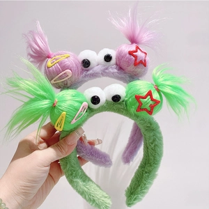Detail of plush purple and green scrunchies with big eyes and star beads charms