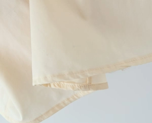Detail of high-density polyester fabric with smooth texture and double-fold hem stitching