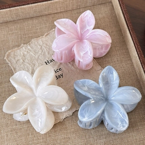 Three elegant marble textured floral hair claws in pink, cream, and light blue colors