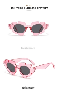 Detail of pink flower shaped sunglasses with transparent frames and dark grey lenses