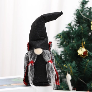 Detail of Halloween gnome with black wizard hat, gray beard, and red cape on a white surface