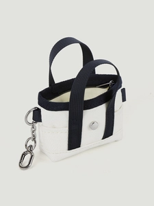Dettaglio mini borsa in tela con manici blu scuro e moschettone metallico argentato