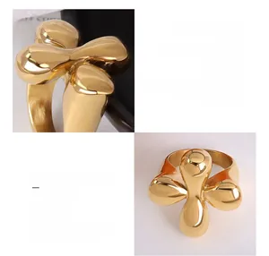 Macro detail of a 18k gold plated titanium steel ring with a smooth cross floral design