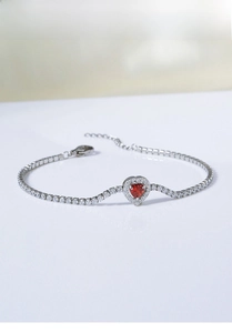 Macro shot of silver titanium steel bracelet with red heart zircon and micro-paved crystals