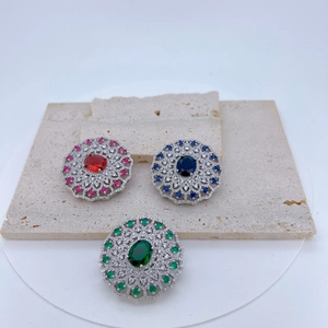 Detailed macro of vintage silver hollow pendants with red, blue, and green gemstones