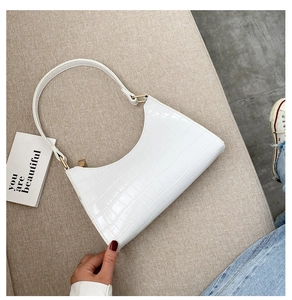 Detail of white crocodile embossed texture on a retro shoulder bag with metal zipper