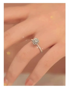 Macro detail of a sparkling round diamond ring with a floral halo and pavé band