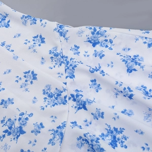 Primo piano di tessuto in chiffon bianco con delicata stampa floreale blu e texture