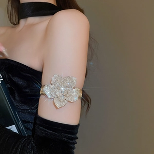Macro detail of adjustable golden camellia upper arm cuff with shimmering crystals