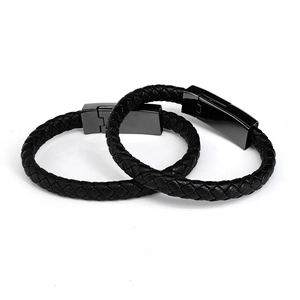 Dual black braided leather charger bracelets with sleek metallic clasps on white background