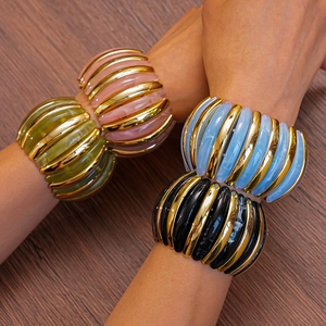 Detail of colorful acrylic resin and gold metal bead bracelets on woman's wrist