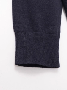 Dettaglio della maglia fine e dei polsini a costine elasticizzati blu scuro