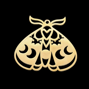 Detailed close-up of a golden moth pendant with cutout moon and heart patterns
