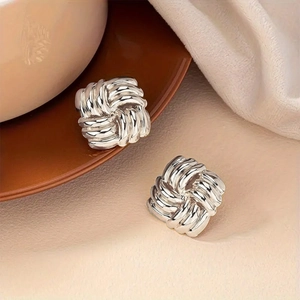 Chic silver woven knot square earrings with a polished mirror finish on soft fabric