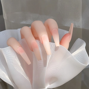Détail de faux ongles cercueil extra-longs avec dégradé rose nude et finition mate