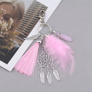 Vista dettagliata di un portachiavi acchiappasogni boho rosa con piuma, nappa e opale