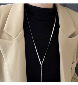 Close-up of a silver snake chain Y-shaped long necklace on a black turtleneck sweater